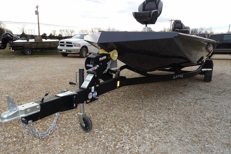 Slide: The Image of 2026 Lund 1875 Renegade boat on trailer, parked on gravel lot. - 36