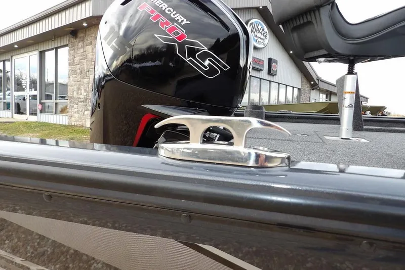 Slide: The Image of 2026 Lund 1875 Renegade boat with Mercury Pro XS engine, docked near a marine center. - 45