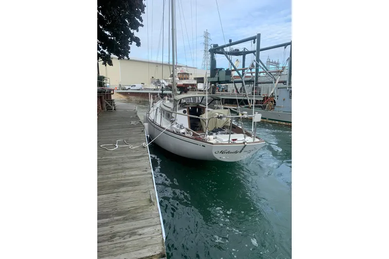 Slide: The Image of 1973 Bristol 40 sailboat docked at marina, calm water, overcast sky. - 11