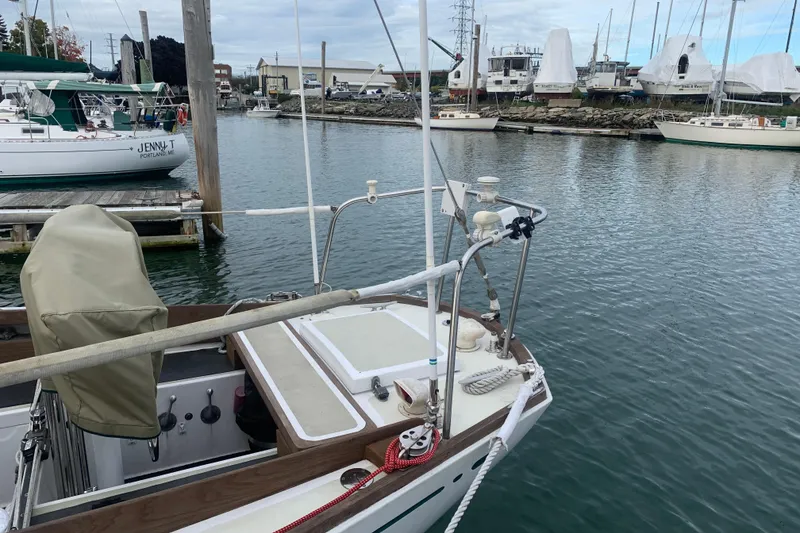 Slide: The Image of 1973 Bristol 40 sailboat docked in a marina with other boats in the background. - 12