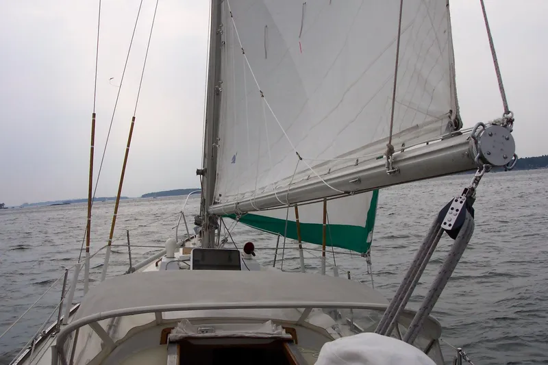 Slide: The Image of Sailing on a 1973 Bristol 40 yacht with white sails on a calm sea. - 9