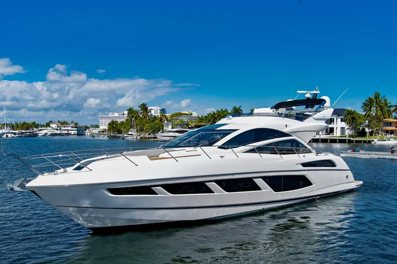 The Image of 2017 Sunseeker 68 Sport Yacht cruising on a sunny day, surrounded by luxury waterfront homes. - 0