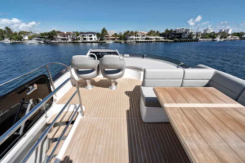Slide: The Image of Luxurious 2017 Sunseeker 68 Sport Yacht deck with seating and table, overlooking waterfront homes. - 10
