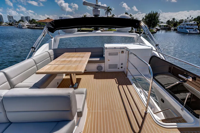 Slide: The Image of Luxurious 2017 Sunseeker 68 Sport Yacht deck with seating and table, docked by waterfront. - 12