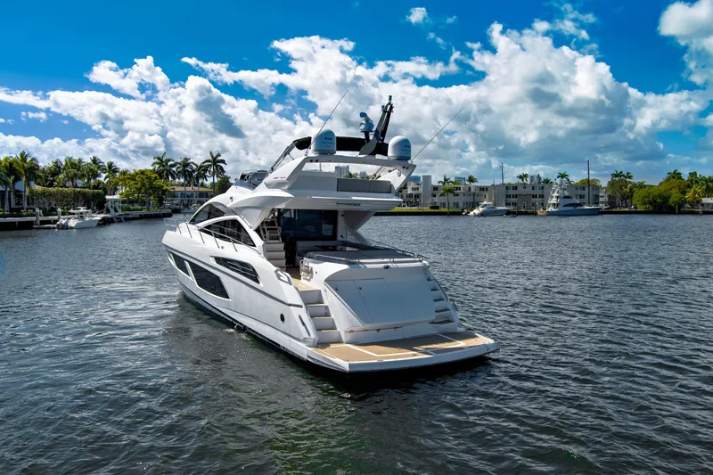 Slide: The Image of 2017 Sunseeker 68 Sport Yacht cruising on a sunny day with palm trees in the background. - 3