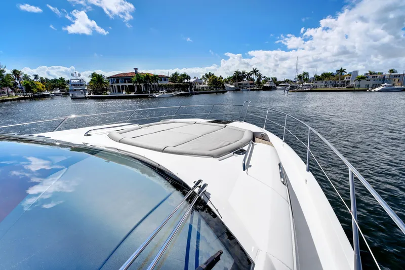 Slide: The Image of Sunseeker 68 Sport Yacht 2017 on a sunny day, cruising near waterfront homes. - 6