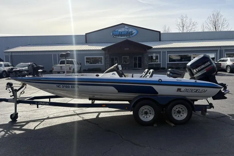 Slide: The Image of 1997 Javelin 400 SE boat on trailer, parked outside a marine center. - 1