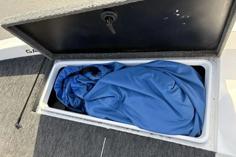 Slide: The Image of Storage compartment in a 1997 Javelin 400 SE boat, containing a blue cover. - 14