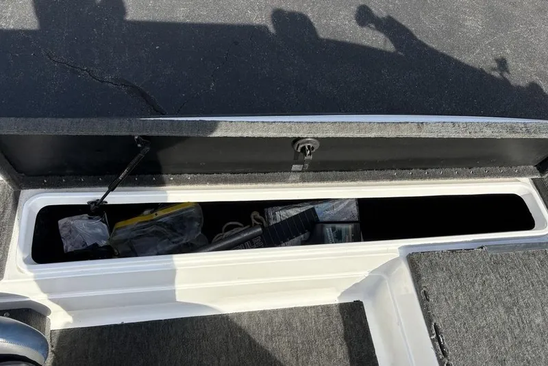 Slide: The Image of Open storage compartment in a 1997 Javelin 400 SE boat, containing various items. - 15