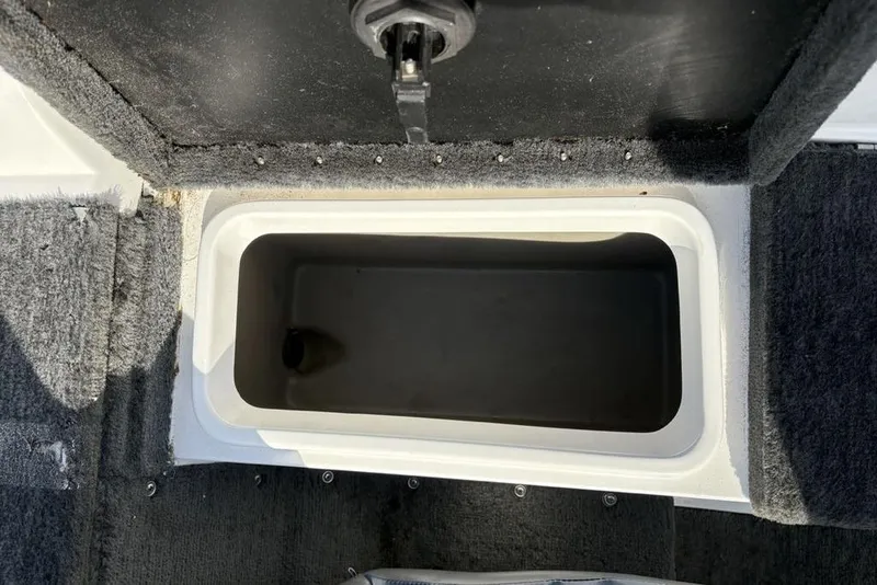 Slide: The Image of Storage compartment in 1997 Javelin 400 SE boat, featuring carpeted interior and secure latch. - 17