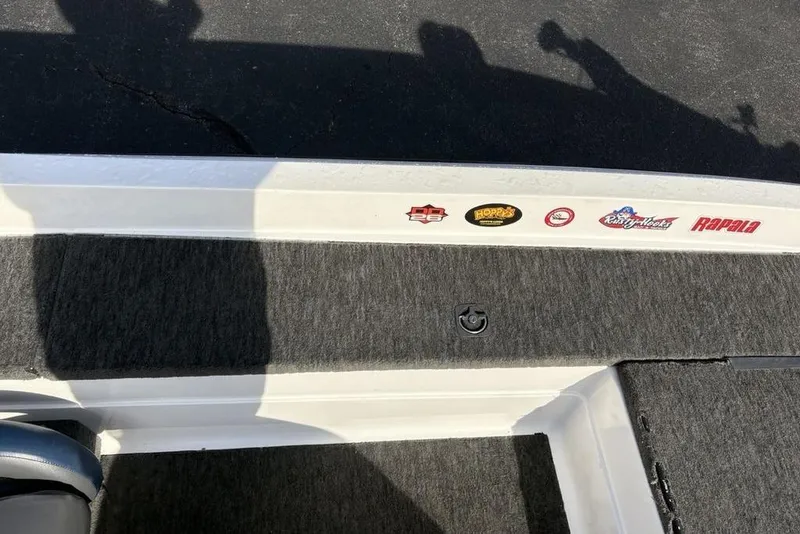 Slide: The Image of 1997 Javelin 400 SE boat deck with various brand stickers and carpeted surface. - 18