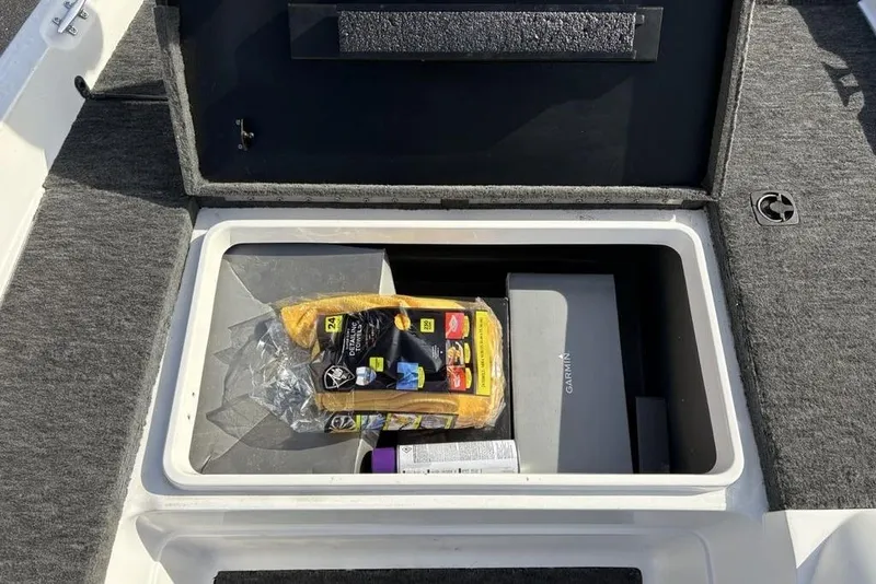 Slide: The Image of Storage compartment in a 1997 Javelin 400 SE boat with cleaning supplies and Garmin box. - 20