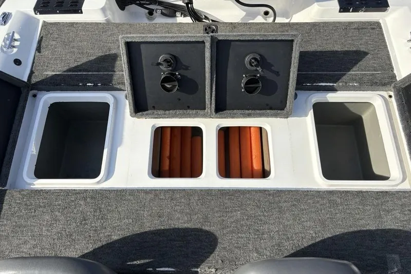 Slide: The Image of 1997 Javelin 400 SE boat storage compartments with gray carpet and open hatches. - 22