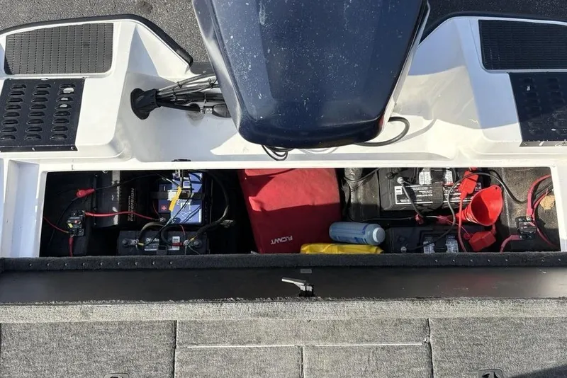 Slide: The Image of 1997 Javelin 400 SE boat battery compartment with equipment and storage items. - 29