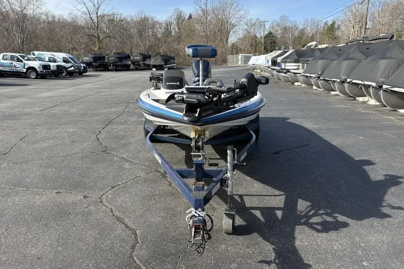 Slide: The Image of 1997 Javelin 400 SE boat on trailer in parking lot, surrounded by trees and vehicles. - 5
