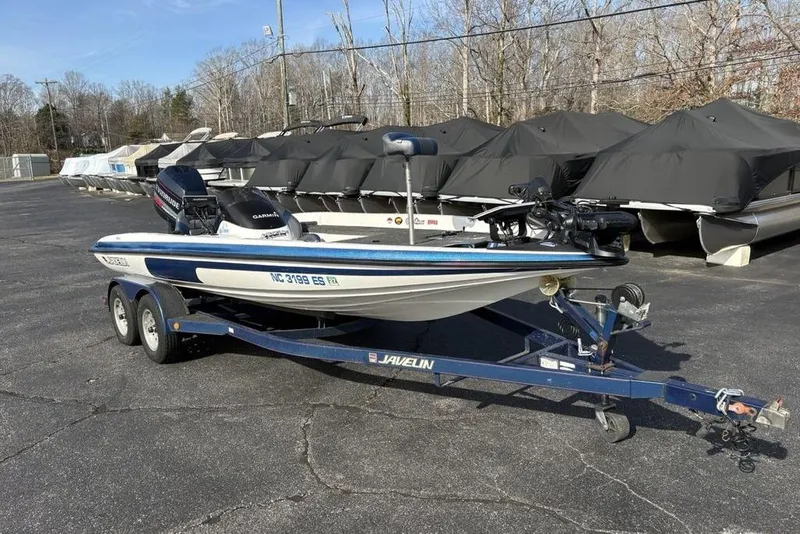 Slide: The Image of 1997 Javelin 400 SE boat on trailer in parking lot, surrounded by covered boats. - 6
