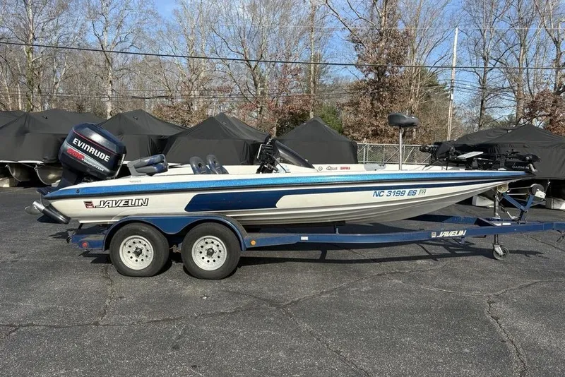 Slide: The Image of 1997 Javelin 400 SE boat on trailer with Evinrude motor, parked outdoors. - 7