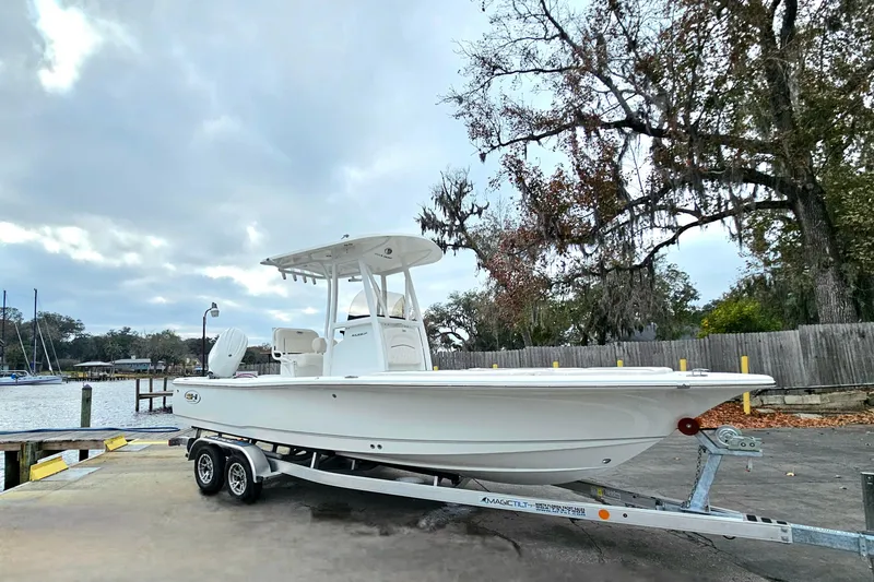 Slide: The Image of 2026 Sea Hunt BX 22 BR boat on trailer by a lakeside dock. - 10