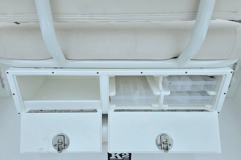 Slide: The Image of 2026 Sea Hunt BX 22 BR boat storage compartments with tackle boxes and secure latches. - 15