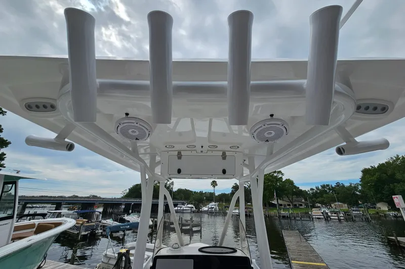 Slide: The Image of 2026 Sea Hunt BX 22 BR boat with rod holders and speakers, docked at a marina. - 16