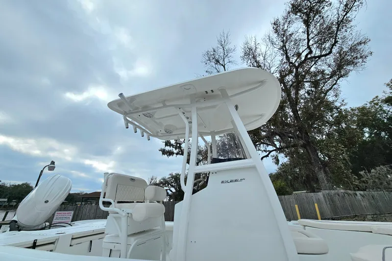 Slide: The Image of 2026 Sea Hunt BX 22 BR boat with T-top, viewed from below, against cloudy sky. - 9