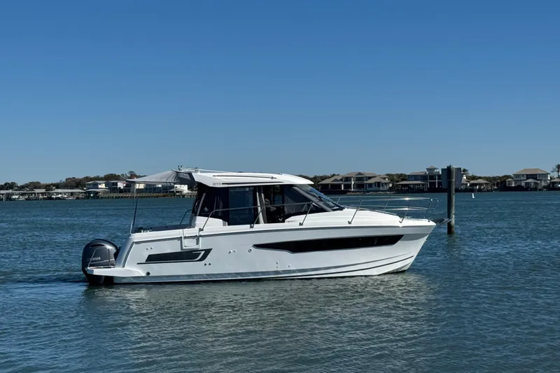 The Image of 2019 Jeanneau NC 895 boat on calm water under clear blue sky. - 0