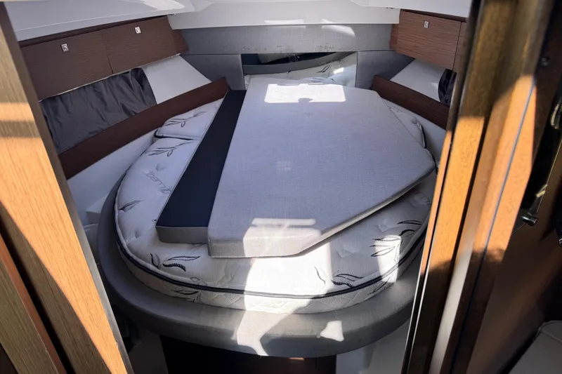 Slide: The Image of 2019 Jeanneau NC 895 cabin interior with cozy bed and wooden accents. - 21
