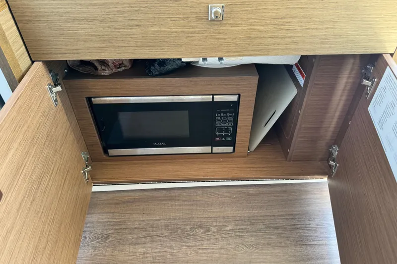 Slide: The Image of 2019 Jeanneau NC 895 interior with built-in microwave in wooden cabinet. - 24
