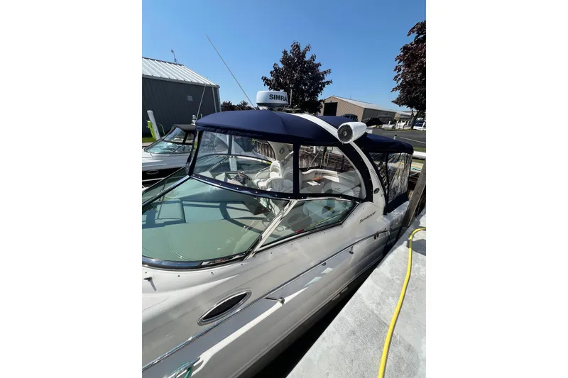 The Image of 2007 Sea Ray 340 Sundancer docked, featuring a blue canopy and sleek design. - 1