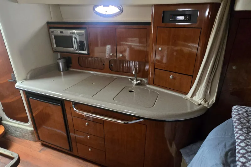 Slide: The Image of 2007 Sea Ray 340 Sundancer galley with wood cabinetry and modern appliances. - 13