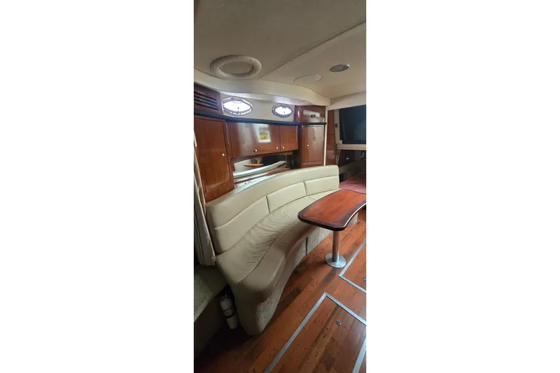 Slide: The Image of 2007 Sea Ray 340 Sundancer interior with curved seating and wooden table. - 14