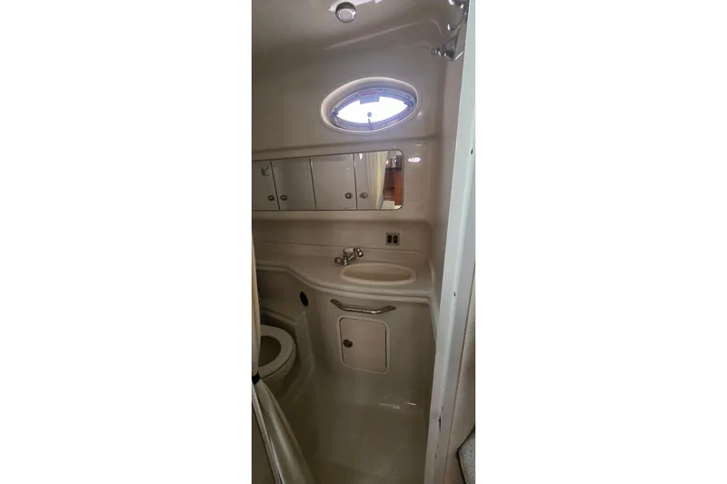 Slide: The Image of 2007 Sea Ray 340 Sundancer bathroom interior with sink, mirror, and storage cabinets. - 17