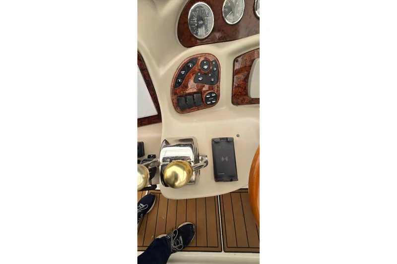 Slide: The Image of 2007 Sea Ray 340 Sundancer helm with controls and gauges, featuring wood accents. - 8