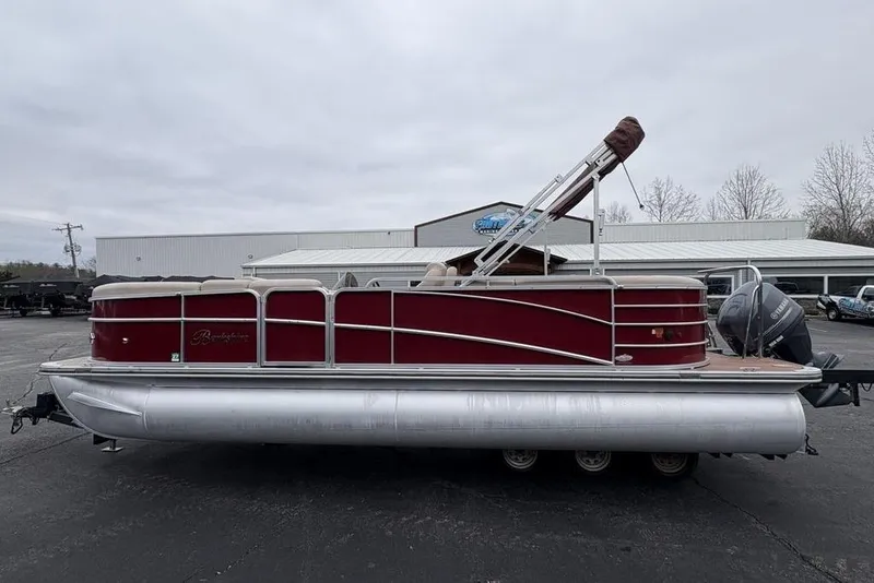 The Image of 2013 Berkshire 233 RFX STS pontoon boat with red exterior, parked on a trailer. - 1