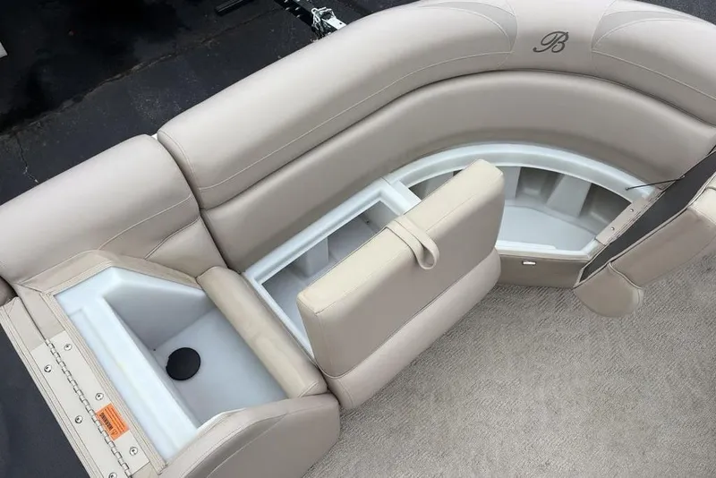 Slide: The Image of 2013 Berkshire 233 RFX STS boat interior with beige seating and storage compartments. - 12