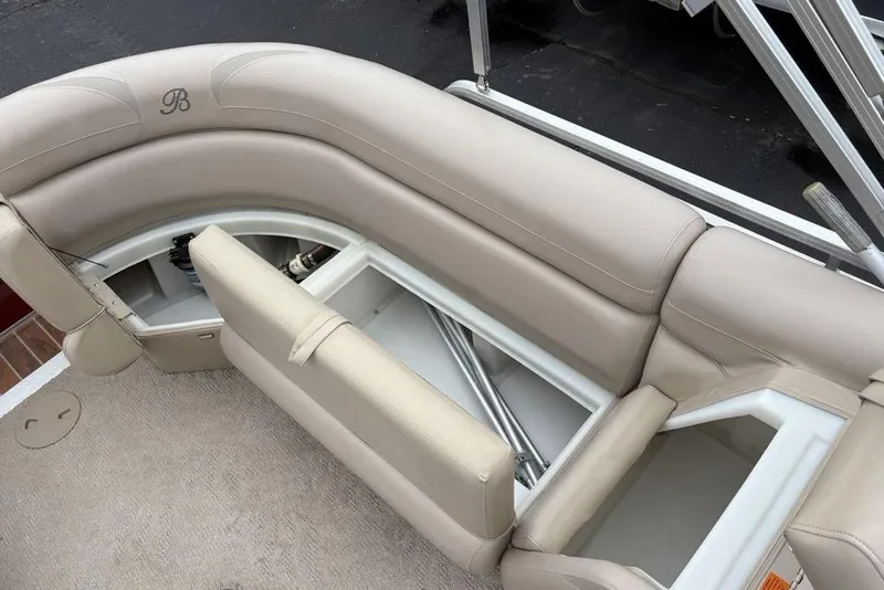 Slide: The Image of 2013 Berkshire 233 RFX STS boat interior with beige seating and storage compartments. - 24