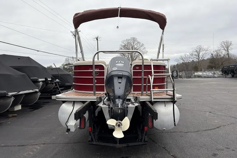 Slide: The Image of 2013 Berkshire 233 RFX STS pontoon boat with outboard motor, parked outdoors. - 4