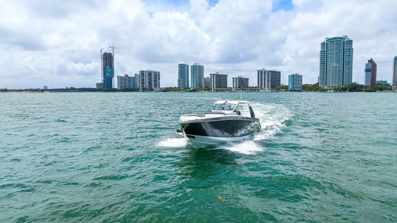 Slide: The Image of 2022 Cigarette 42 Auroris boat cruising on water with city skyline in background. - 13