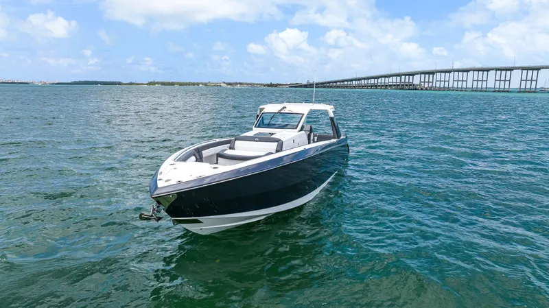 Slide: The Image of 2022 Cigarette 42 Auroris boat on open water near a bridge under blue skies. - 5