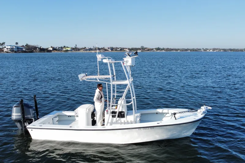 The Image of 1987 Privateer 22 Roamer boat on calm water with a person onboard, clear sky background. - 0