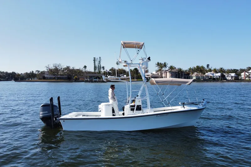 Slide: The Image of 1987 Privateer 22 Roamer boat on calm water, featuring a Yamaha outboard motor. - 1