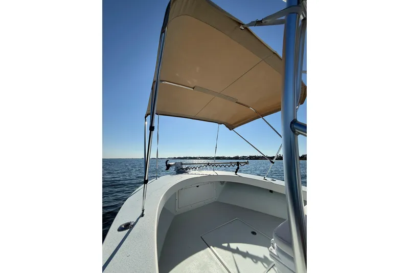 Slide: The Image of 1987 Privateer 22 Roamer boat with canopy on calm water. - 11