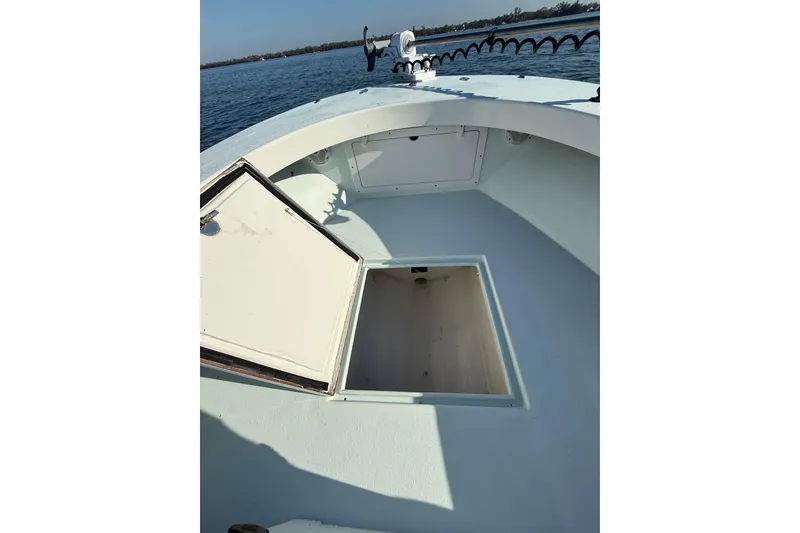 Slide: The Image of 1987 Privateer 22 Roamer boat with open storage compartment on calm water. - 15