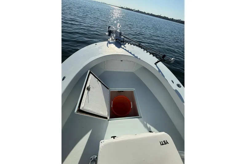 Slide: The Image of 1987 Privateer 22 Roamer boat on calm water, open hatch with orange bucket. - 16