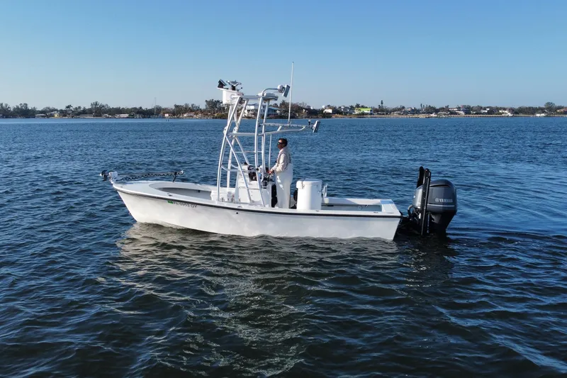 Slide: The Image of 1987 Privateer 22 Roamer boat on calm water with Yamaha outboard motor. - 2