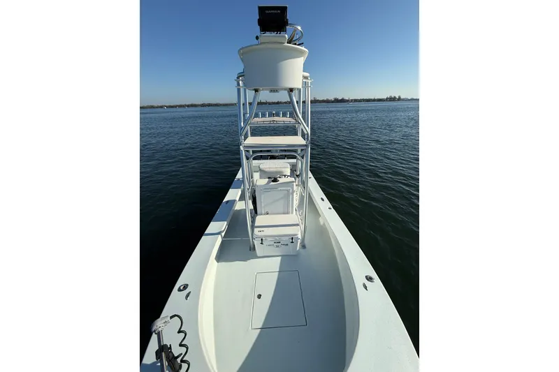 Slide: The Image of 1987 Privateer 22 Roamer boat on calm water, featuring elevated helm and open deck. - 21