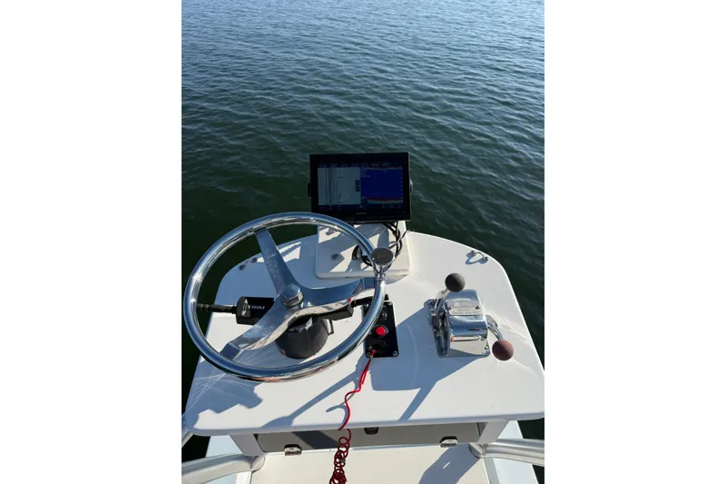 Slide: The Image of Steering console of a 1987 Privateer 22 Roamer boat on calm water. - 23
