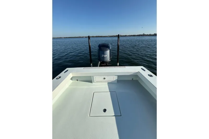 Slide: The Image of 1987 Privateer 22 Roamer boat on calm water, featuring a powerful outboard motor. - 29