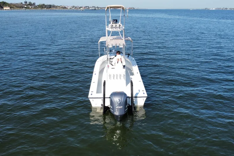 Slide: The Image of 1987 Privateer 22 Roamer boat on calm water, rear view with outboard motor. - 9