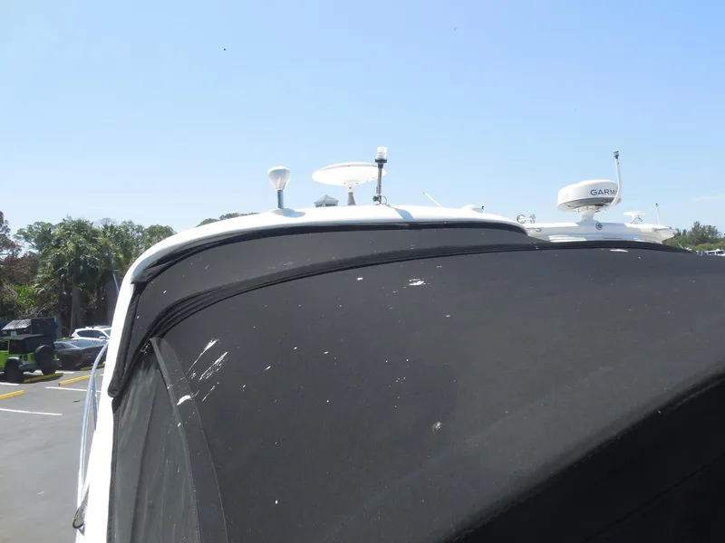 Slide: The Image of 2007 Sea Ray 290 Sundancer boat with black canvas cover and radar equipment. - 27